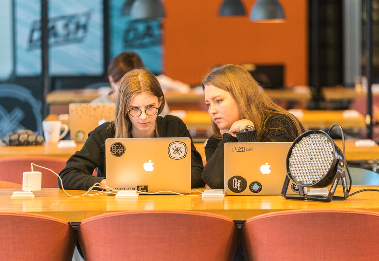 Zwei Frauen sitzen am Laptop.